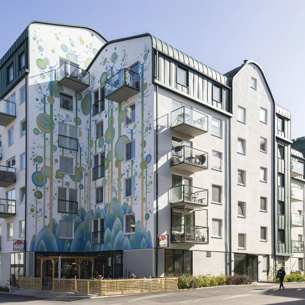 Ett flerbostadshus med färgglad muralmålning på fasaden
