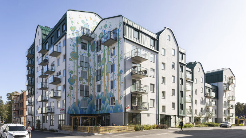 Ett flerbostadshus med färgglad muralmålning på fasaden
